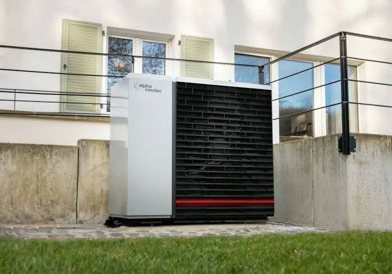 Heat pump outdoor unit beside a house